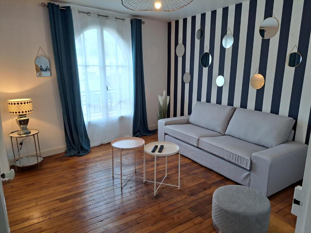 un salon avec un canapé et une table dans l'établissement Chez Léon - Vue cathédrale - Hyper centre ville, à Reims
