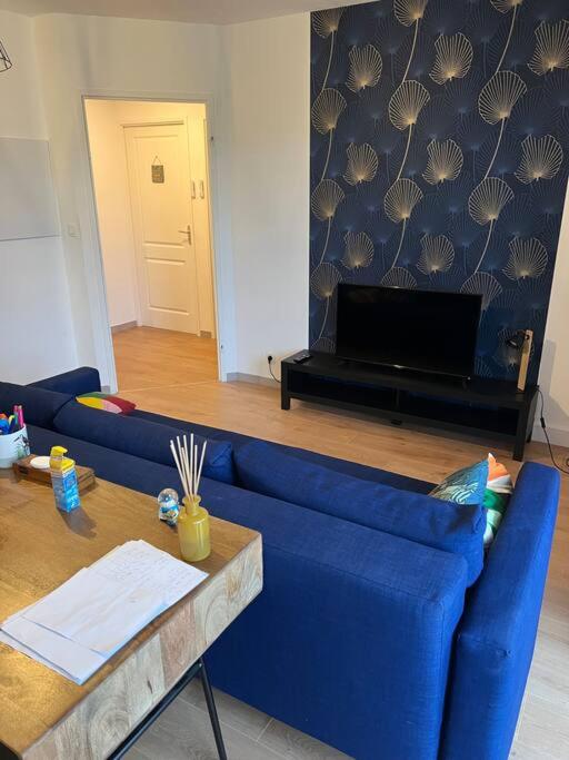 un salon avec un canapé bleu et une table dans l'établissement Le Petit Bruxelles au calme, à Toulouse