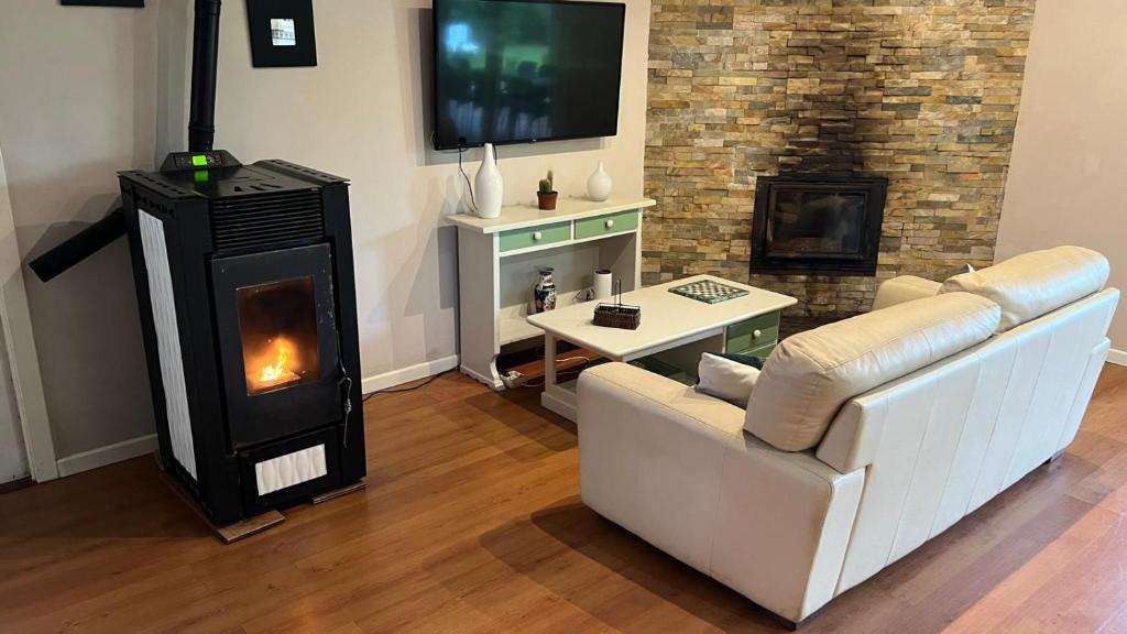 salon z kanapą i kominkiem w obiekcie CASAPUEBLO Arzúa w mieście Campo