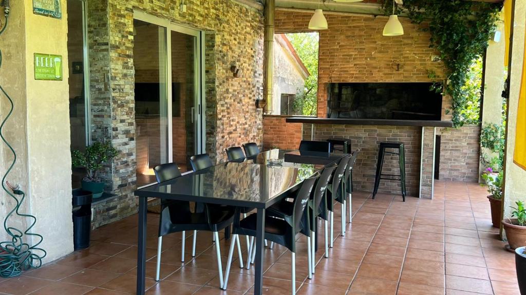 patio z czarnym stołem i krzesłami oraz kominkiem w obiekcie CASAPUEBLO Arzúa w mieście Campo