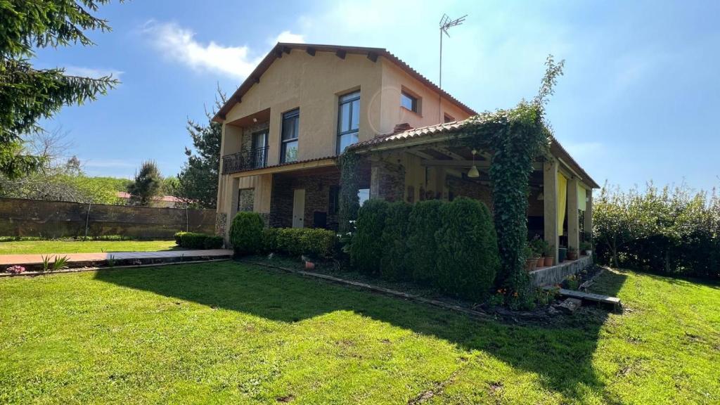 dom z zielonym ogródkiem przed nim w obiekcie CASAPUEBLO Arzúa w mieście Campo