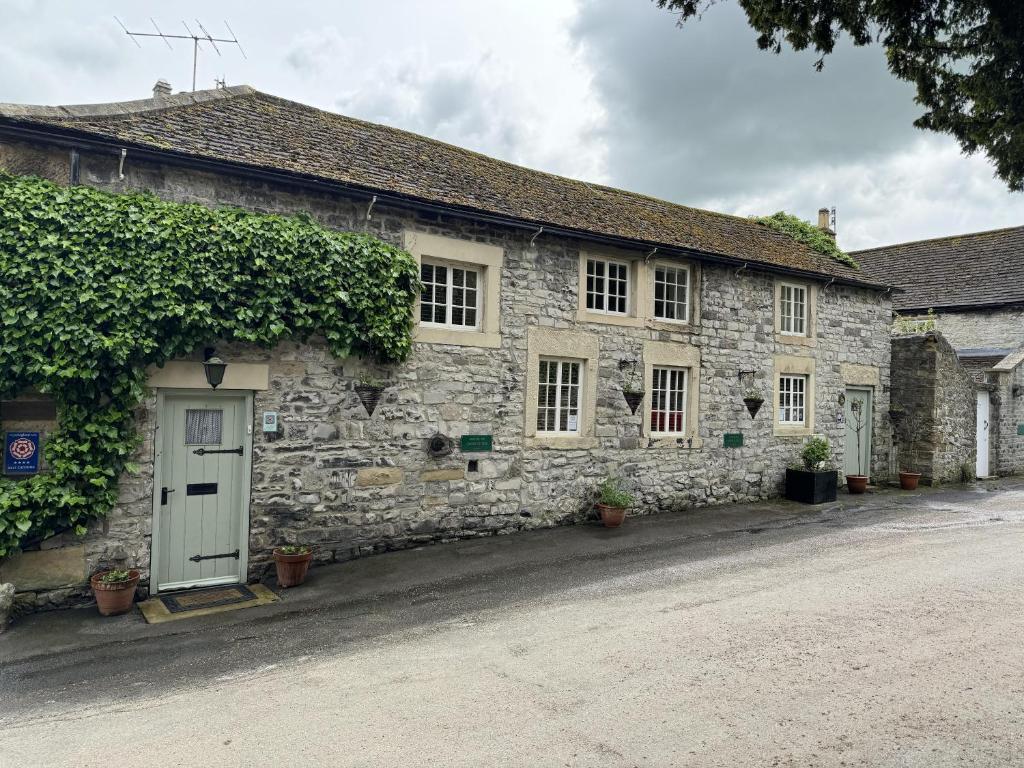 an old stone house with a green door and ivy at Stunning cottage - 3 Bedrooms & 3 Bathrooms in Bakewell
