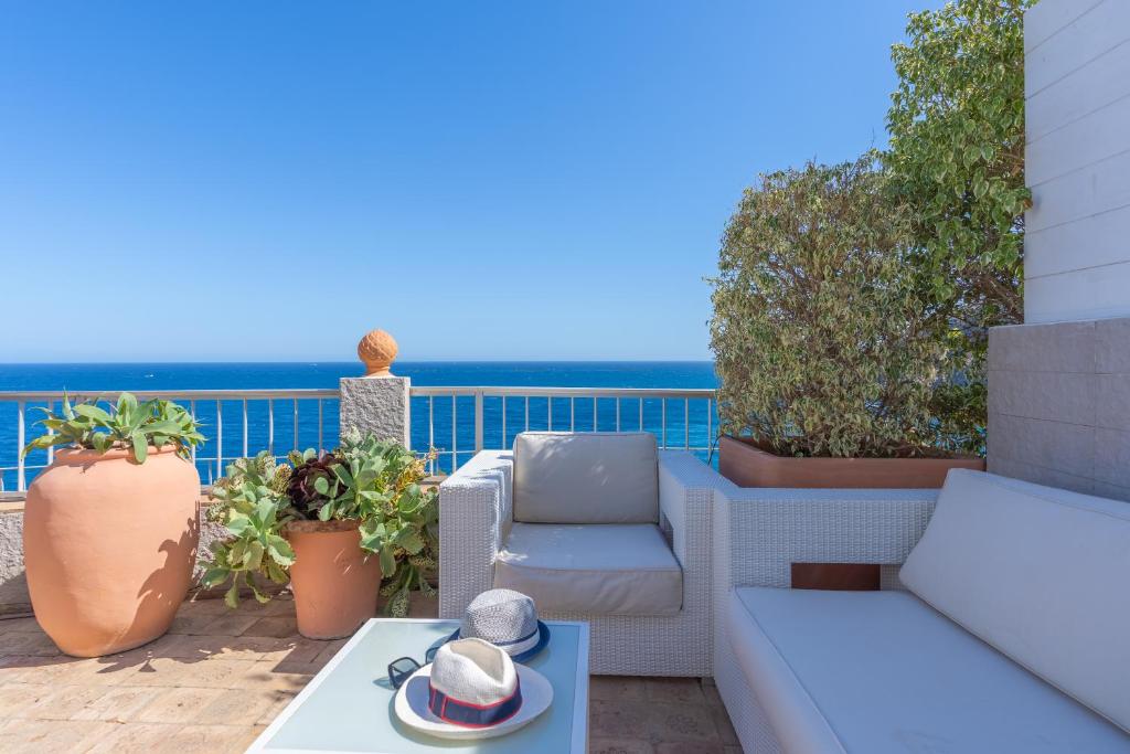 a patio with furniture and the ocean in the background at Maryvilla Inspiración y Vacaciones - Bungalows in Calpe
