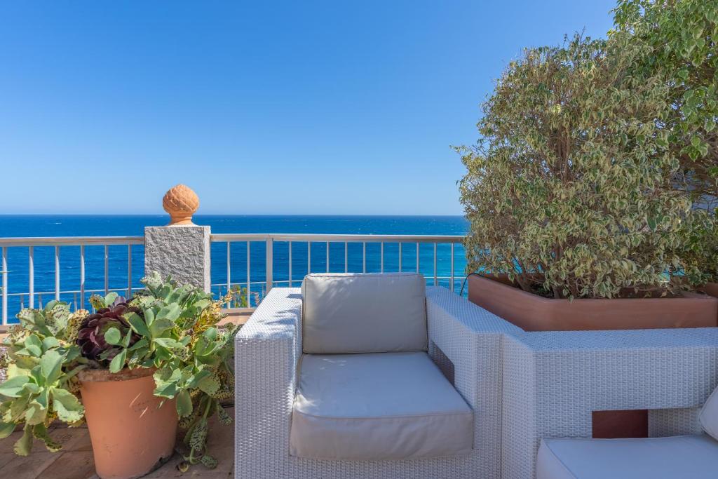 a white chair sitting on a balcony with plants at Maryvilla Inspiración y Vacaciones - Bungalows in Calpe