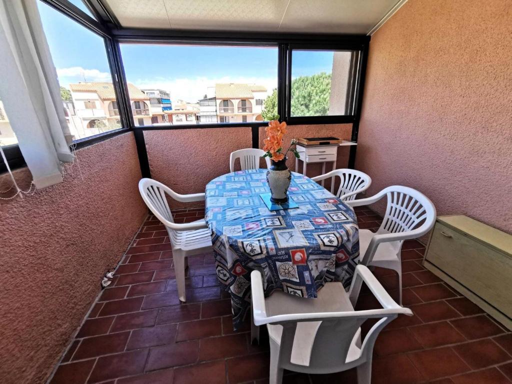 d'une table et de chaises sur un balcon avec une table et un vase dans l'établissement Résidence Maisons Des Sables 4 - APPT T2 CAB OU MEZZ 5 couchages PORT LEUCATE MAE-4931, à Leucate