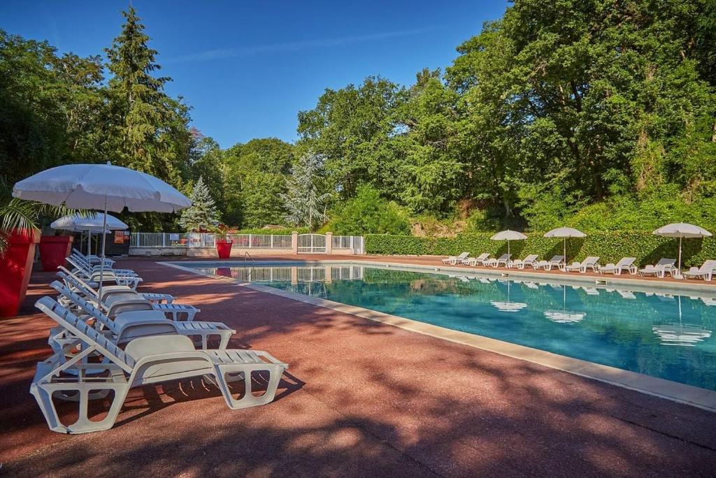 une piscine avec chaises longues et parasols dans l'établissement Mobilhome 3 Ch climatisé à 45 mn de Paris, à Saint-Chéron