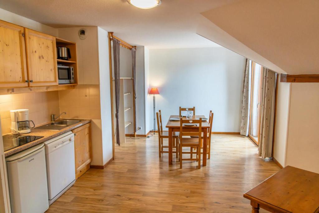 une cuisine et une salle à manger avec une table et des chaises dans l'établissement Résidence Les Hauts De Preclaux - Studio au coeur des Orres 1800 MAE-9591, aux Orres