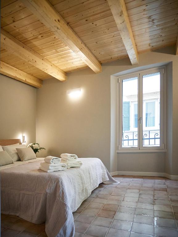 a bedroom with a bed and a large window at Ca' Martini Apartments in Peschiera del Garda