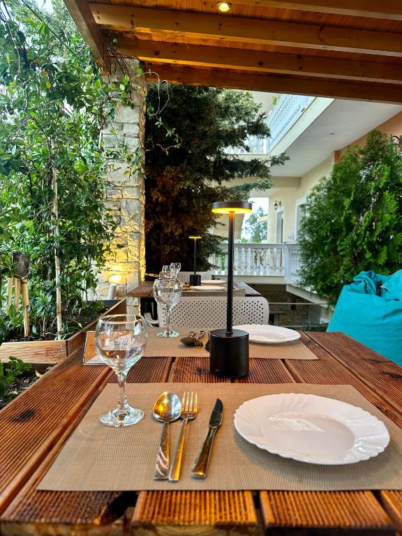 a wooden table with plates and wine glasses on it at Vila Arial in Vlorë