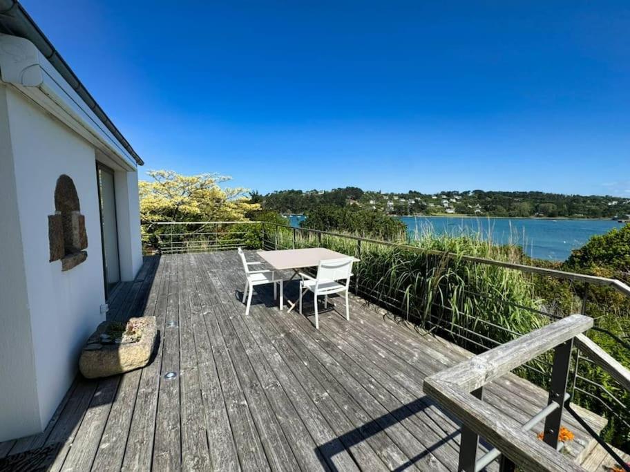 a wooden deck with a table and chairs on it at Ker Agak Maison vue mer panoramique pour 7 pers in Plougasnou