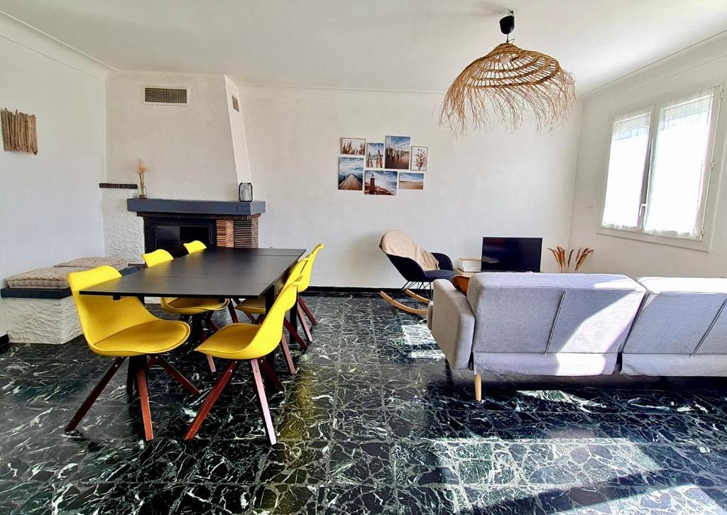 un salon avec une table, des chaises et un canapé dans l'établissement L'Escale Marine à 2 mn à pied de la plage - 2CH, au Barcarès