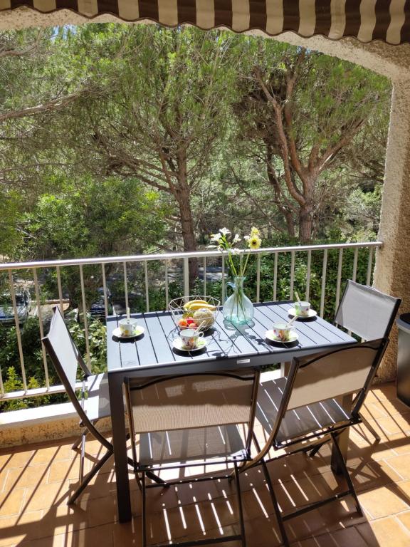 une table et des chaises sur une terrasse arborée dans l'établissement Studio climatisé, parking, 5mn de la plage, à Saint-Cyr-sur-Mer