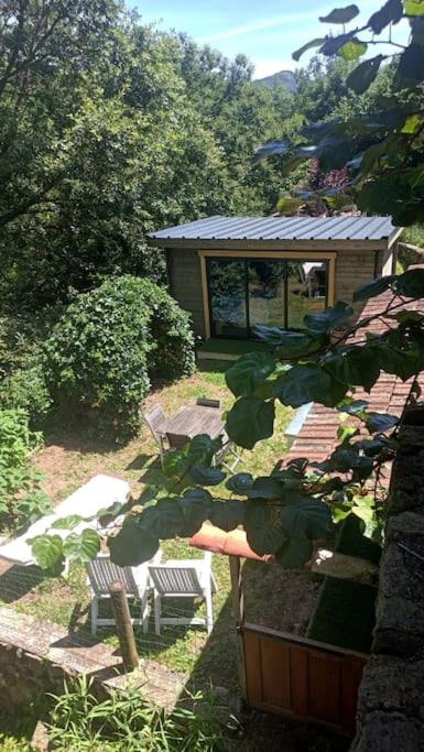 un jardin avec deux chaises et un banc ainsi qu'un bâtiment dans l'établissement Chalet en Ardèche, à Fabras