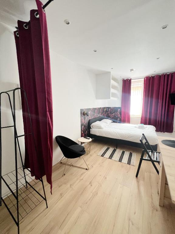 une chambre avec un lit, une table et une chaise dans l'établissement Le Stalingrad - Gare - Centre, à Toulouse