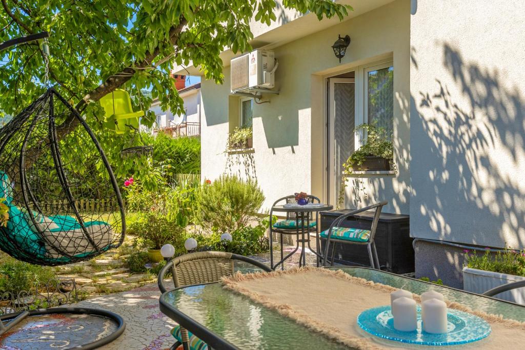 a patio with a table and chairs in front of a house at Cozy Home with Private Garden - Happy Rentals in Dražice
