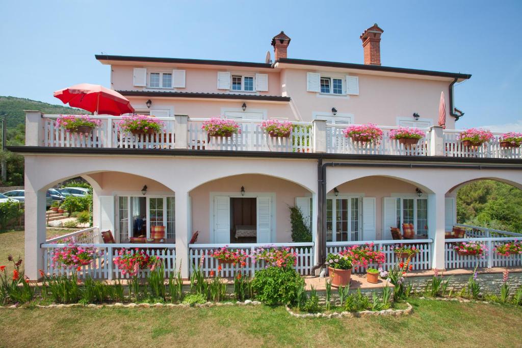 una casa grande con flores en el balcón en Villa Lidija, en Labin