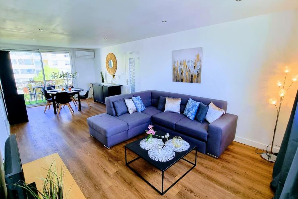 un salon avec un canapé bleu et une table dans l'établissement LE CLERVILLE Rénové Terrasse Climatisation Parking, à Sète