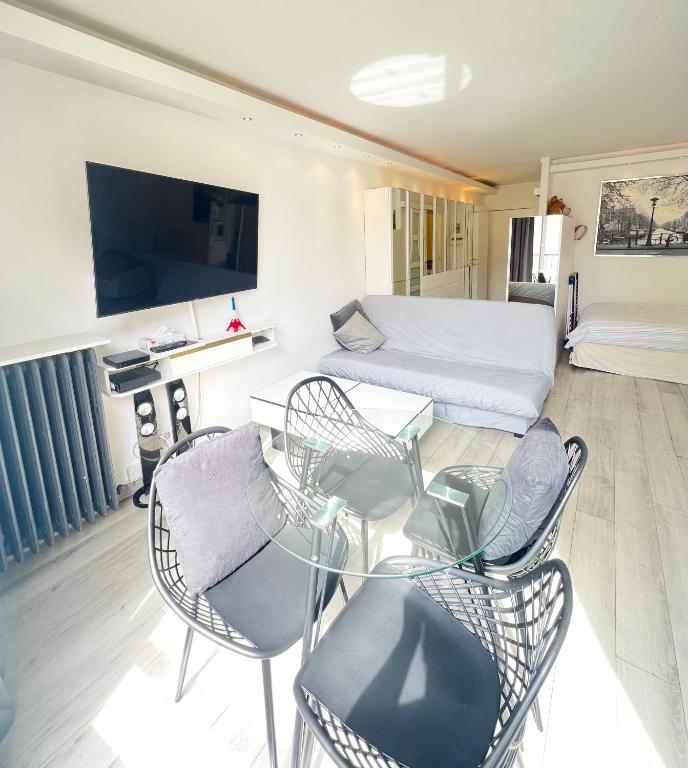 une chambre avec un lit, une table et des chaises dans l'établissement Apartment Like HOME Arc de Triomphe, Champs Élysées, Tour Eiffel, à Paris