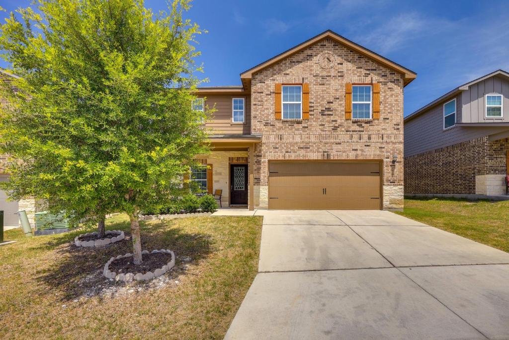 a house with a tree and a garage at San Antonio Home with Fenced-In Yard Steps to Park! in San Antonio