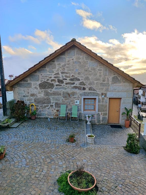 a stone building with two chairs in front of it at Casa da Avó in Cetos