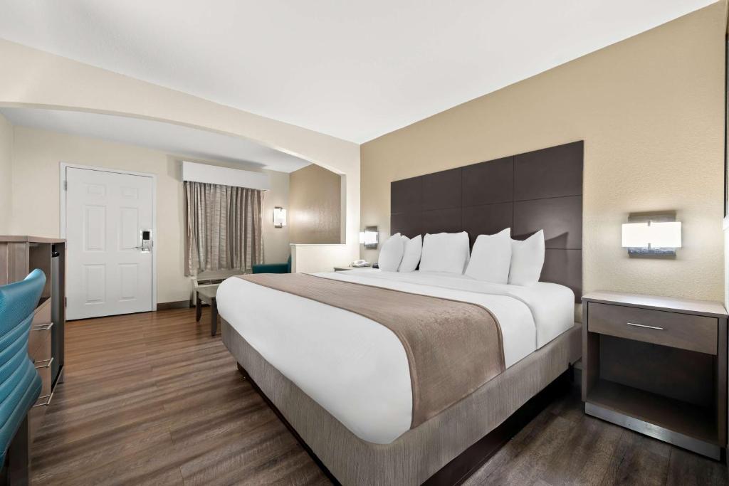 a hotel room with a large bed and a desk at Best Western Catalina Inn in Tuscaloosa