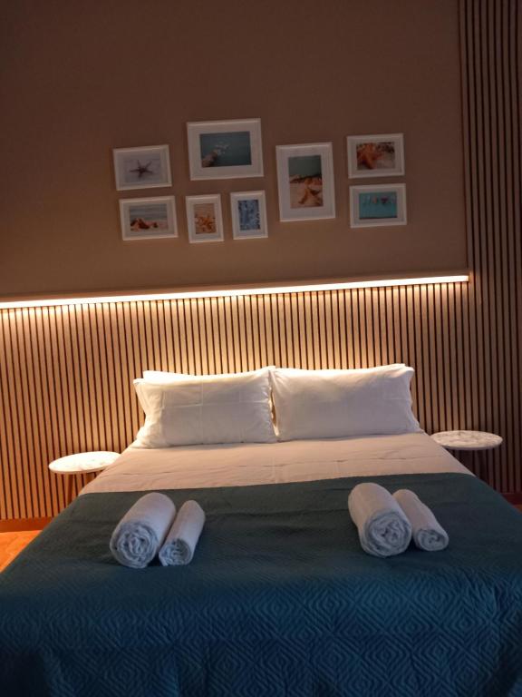 1 dormitorio con 1 cama con 2 pares de toallas en FRONTE MARE apartment, en Barcellona-Pozzo di Gotto