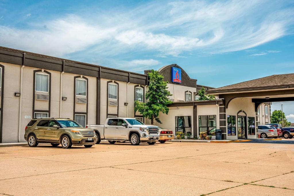 two cars parked in a parking lot in front of a building at Studio 6 Claremore OK in Claremore