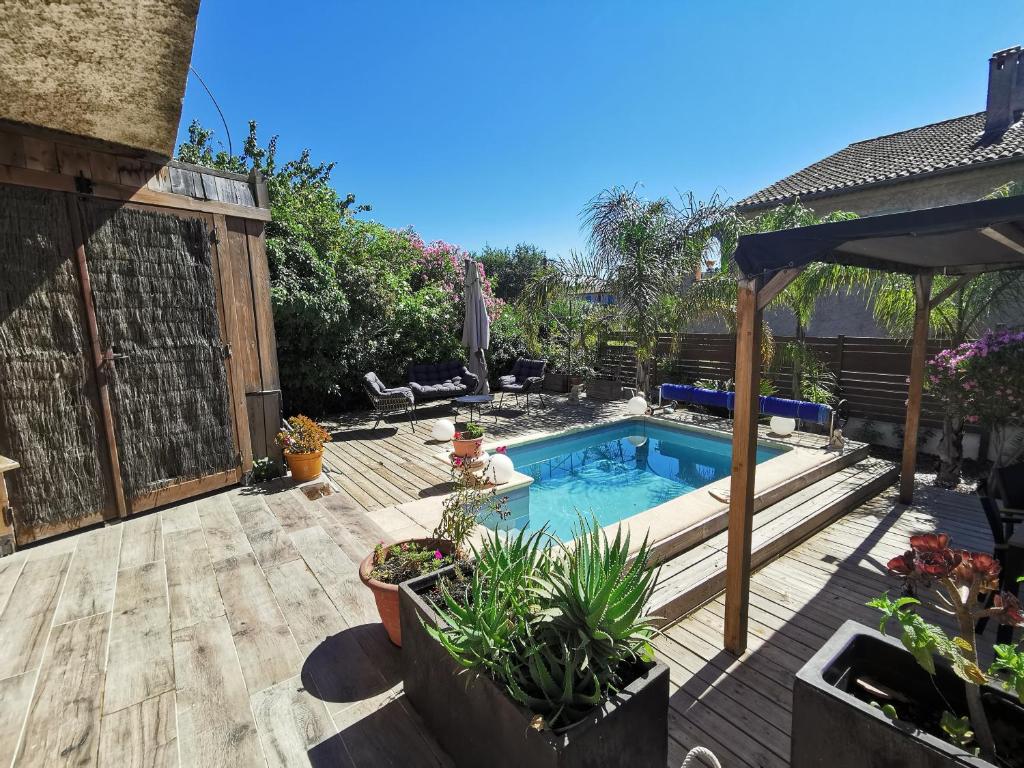 un cortile con piscina e terrazza in legno di Bas de villa avec jardin, piscine et jacuzzi a La Seyne-sur-Mer