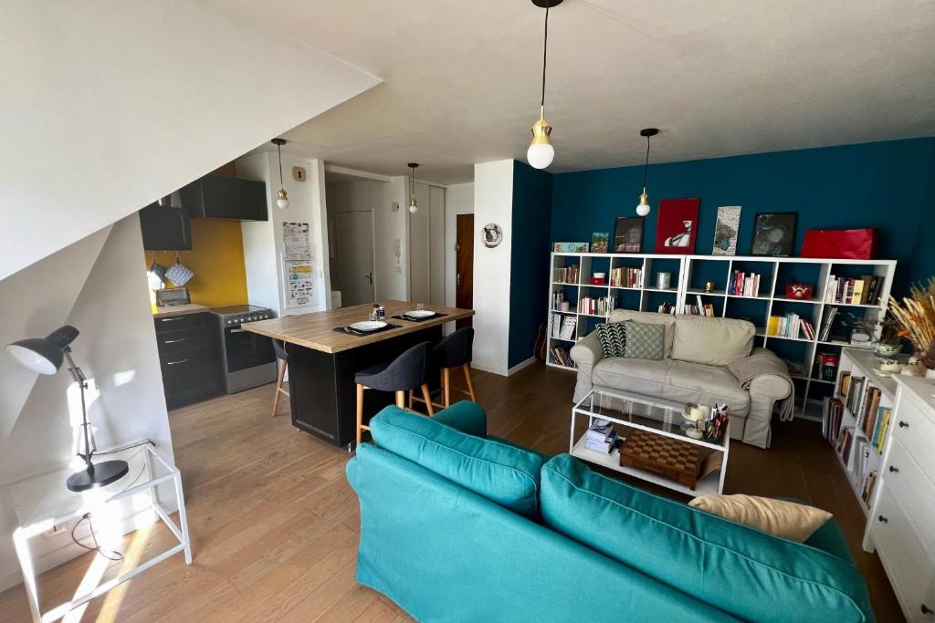 un salon avec un canapé bleu et une table dans l'établissement Charming 2 rooms near hypercenter, à Nantes