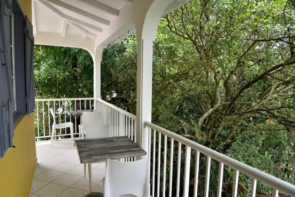 a porch with a bench and a tree at Appartement charmant à Le Gosier avec vue sur la mer, 110 m² in Le Gosier