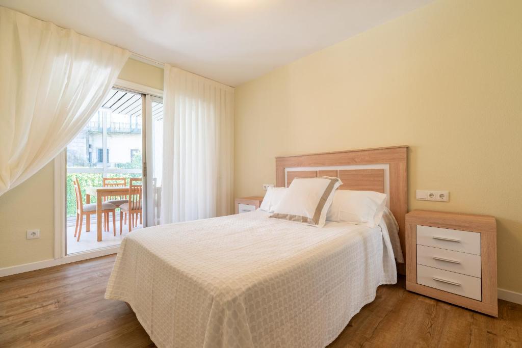 Un dormitorio con una cama y un balcón con una mesa. en Apartamento Cánovas Vigo Center, en Vigo