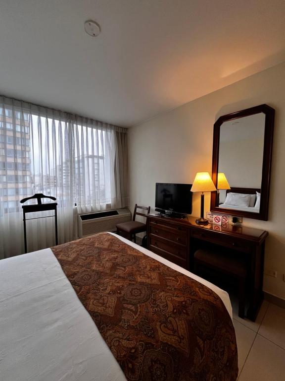 a hotel room with a large bed and a mirror at Hotel Boulevard in Lima