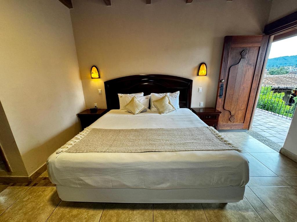 a bedroom with a large bed and a large window at Parador Margarita in San Crist&oacute;bal de Las Casas
