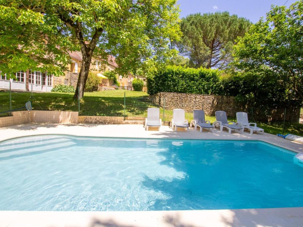 - une piscine avec des chaises longues dans la cour dans l'établissement Maison périgourdine avec piscine, 7 pers, jardin, cheminée - FR-1-616-111, à Saint-Avit-Sénieur