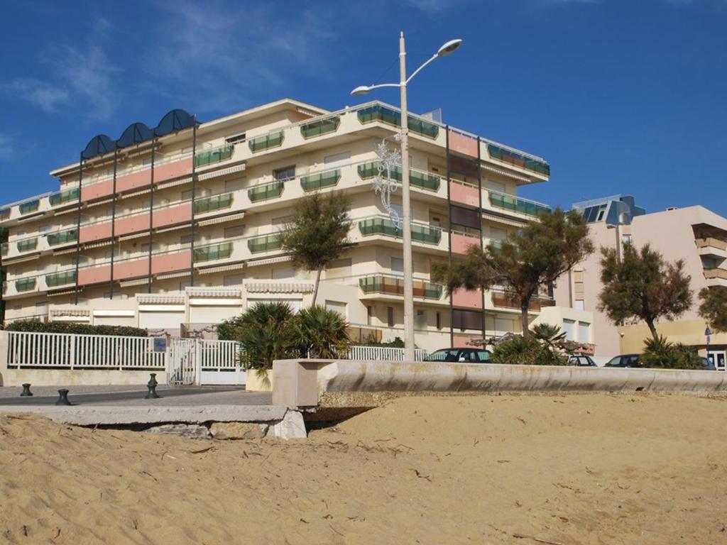 - un bâtiment sur la plage à côté d'une plage de sable dans l'établissement Studio en Rez-de-Jardin, 2 Couchages, à 10m de la Plage du Lavandou, Parking, Clim, Tennis. - FR-1-803-10, au Lavandou
