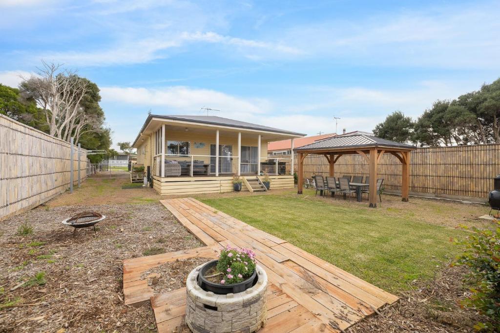 a backyard with a house with a wooden deck at Cooinda at The Cape in Cape Woolamai