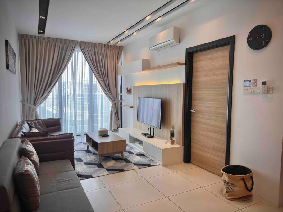 a living room with a couch and a television at Jk DeLOFTS 03 6Pax 150Mbps 2BedR 2BathR 1Carpark in Kuching