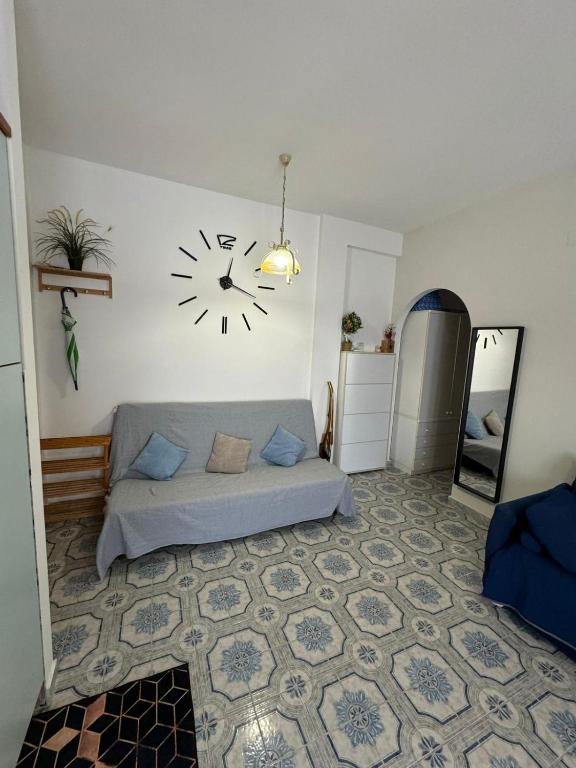a room with a bed and a clock on the wall at Appartamento Primavera in Scalea