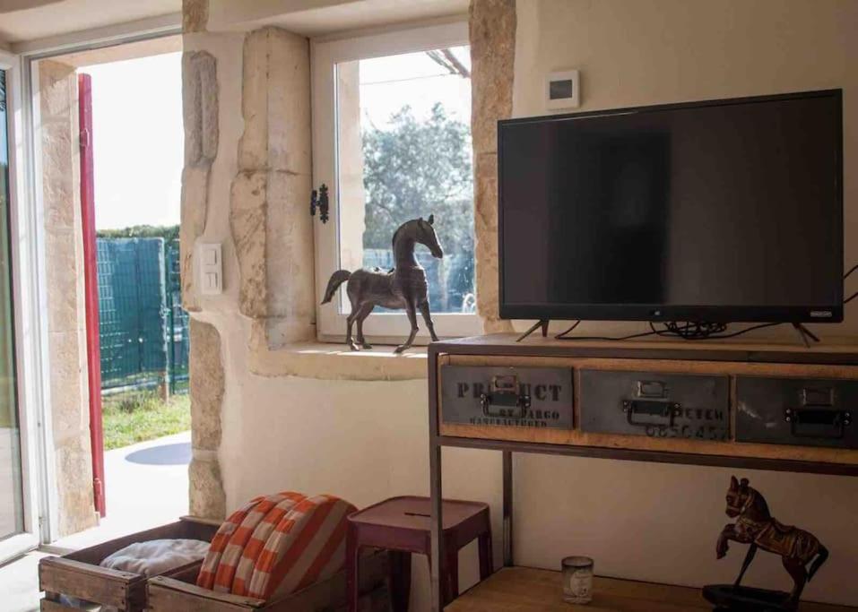 un salon avec une télévision et une statue de cheval dans l'établissement Mazet en Provence dans propriété équestre, à Graveson