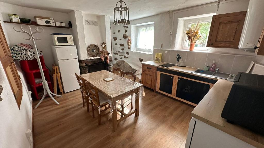 une cuisine avec une table et une salle à manger dans l'établissement Gite en Cevennes 4 personnes, à Ponteils-et-Brésis