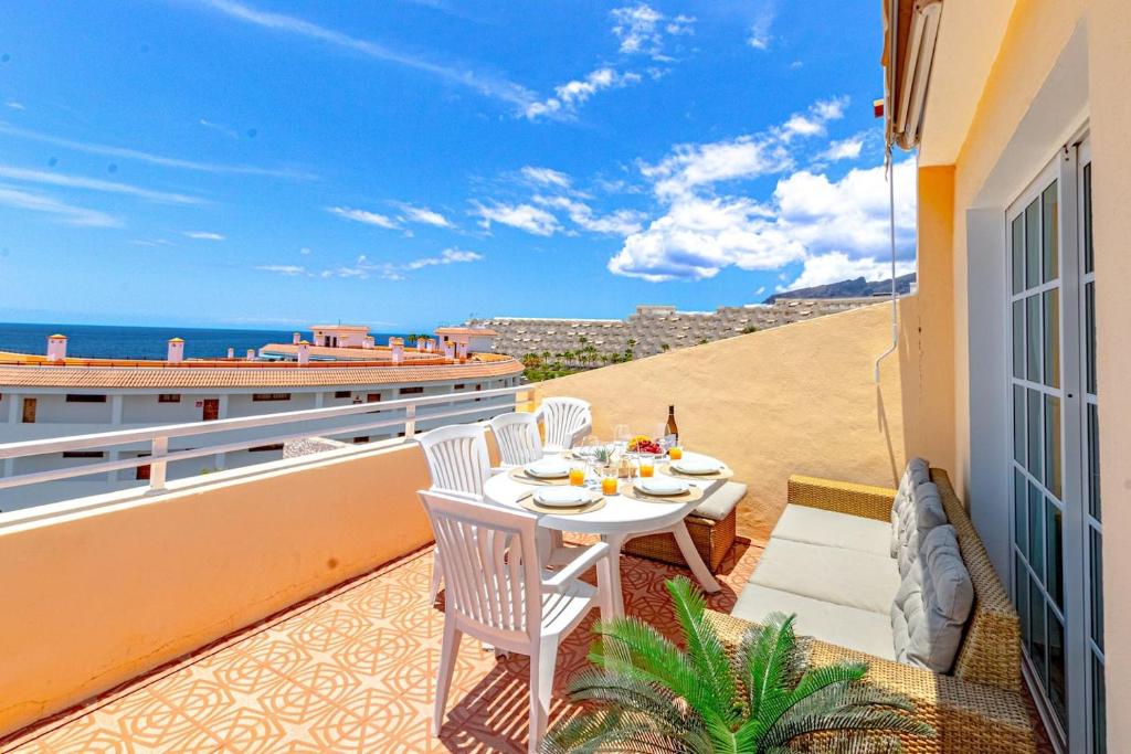 balkon ze stołem i krzesłami i widokiem na ocean w obiekcie Sunny Arena Sol Apt By Dream Homes Tenerife w mieście Puerto de Santiago