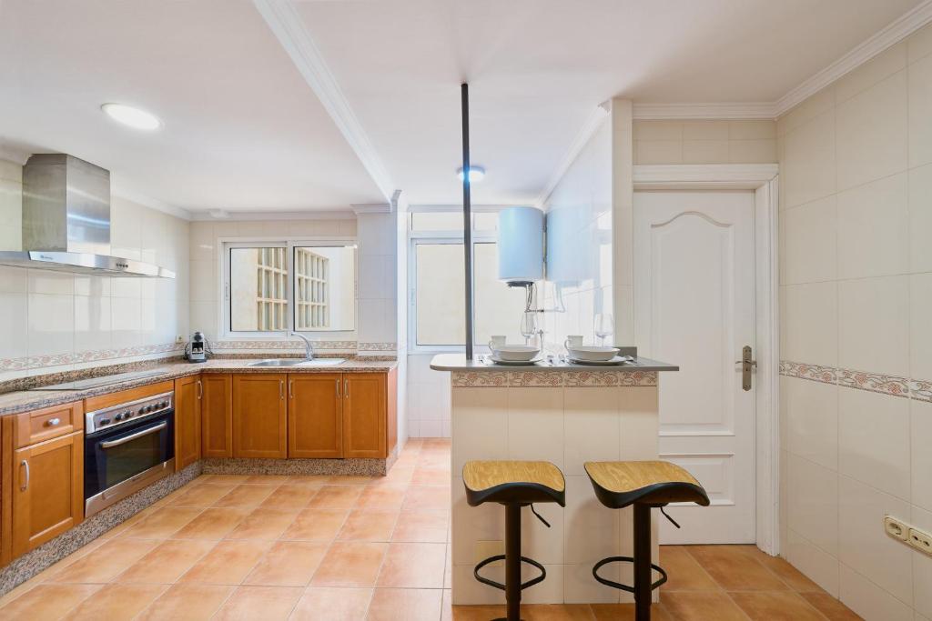 una cucina con un bancone e due sgabelli di Soho Malaga by Lovely Home a Málaga