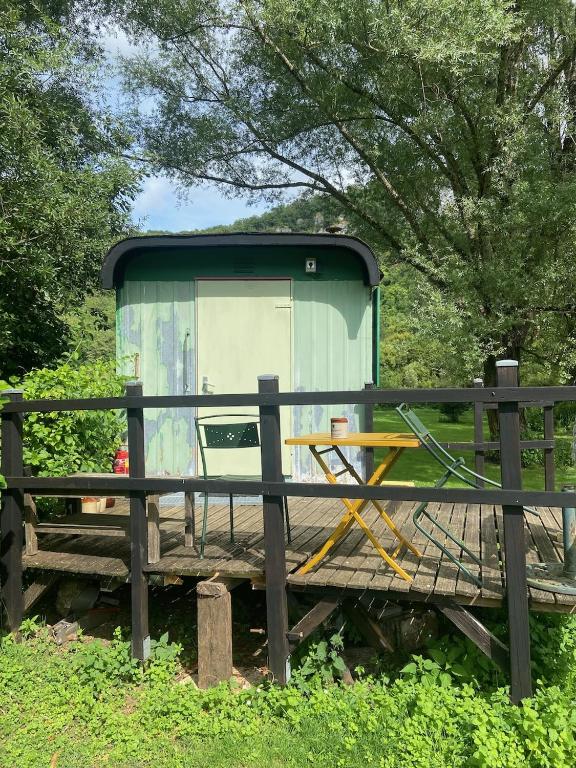 une dépendance posée sur une terrasse en bois dans l'établissement pipowagen Blagour midden in de natuur, à Lachapelle-Auzac