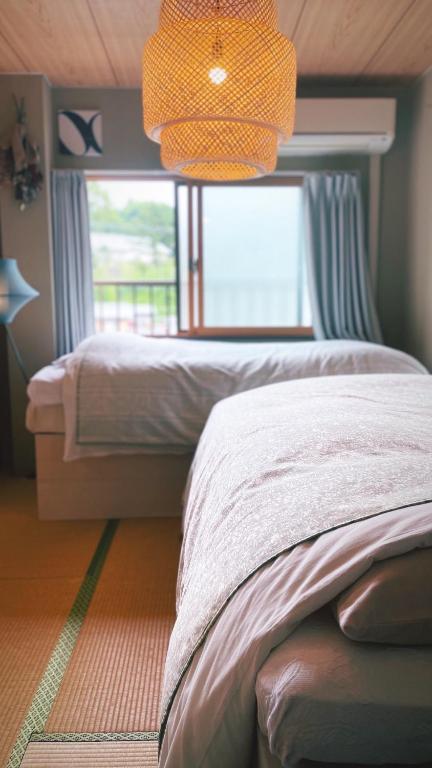 Un dormitorio con una cama y una ventana grande. en 民泊宿 i s e s h i m a 伊勢内宮前203, en Ise