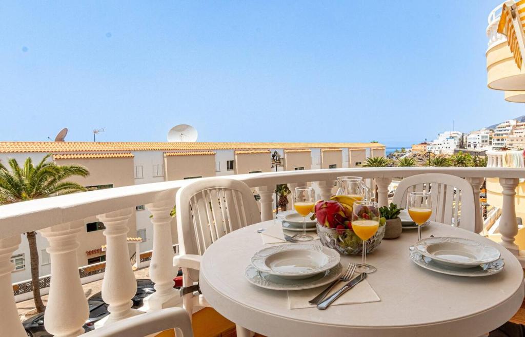 a table on a balcony with a view of the ocean at Seaside Escape 2bed By Dream Homes Tenerife in Puerto de Santiago