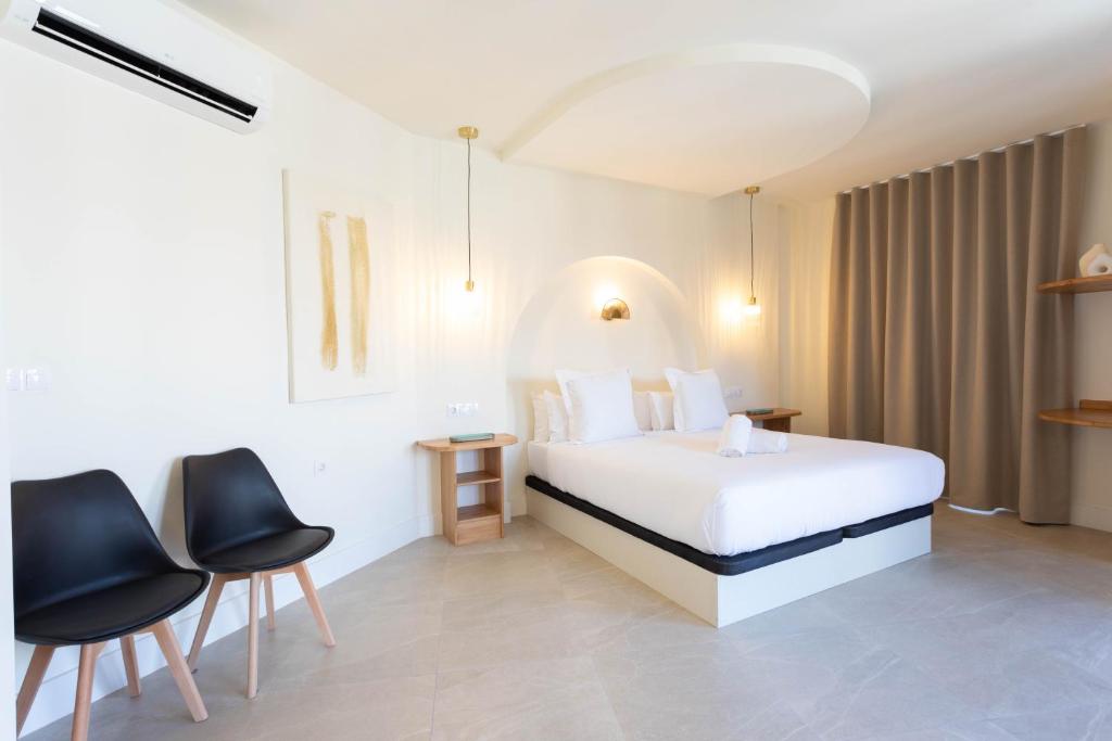 a hotel room with a bed and two chairs at Reina Victoria El Mercado in Alicante