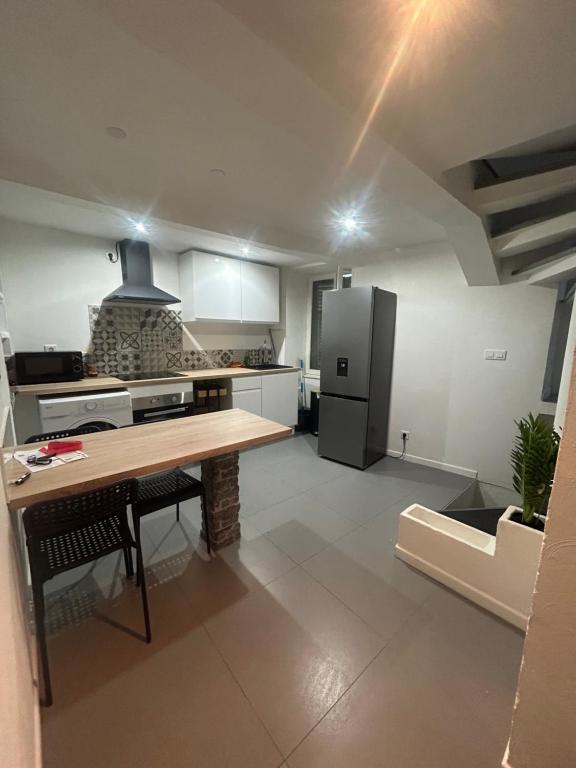a kitchen with a wooden table and a refrigerator at Maison de village in Berre-les Alpes