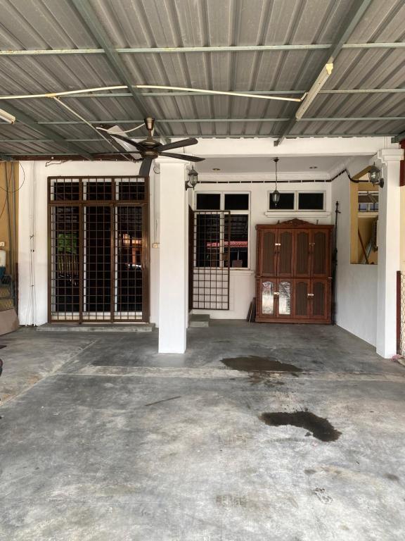 Un garaje vacío con techo de metal y una puerta. en Shaida homestay, en Kota Bharu