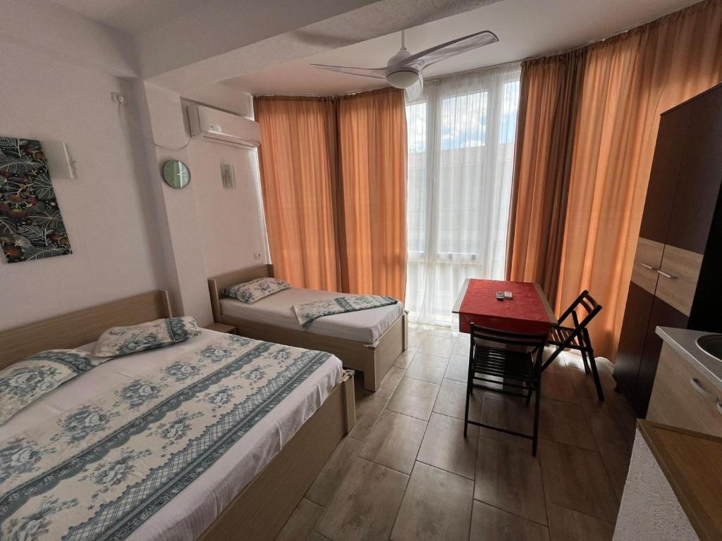a hotel room with two beds and a table at Camere de inchiriat David in Eforie Nord