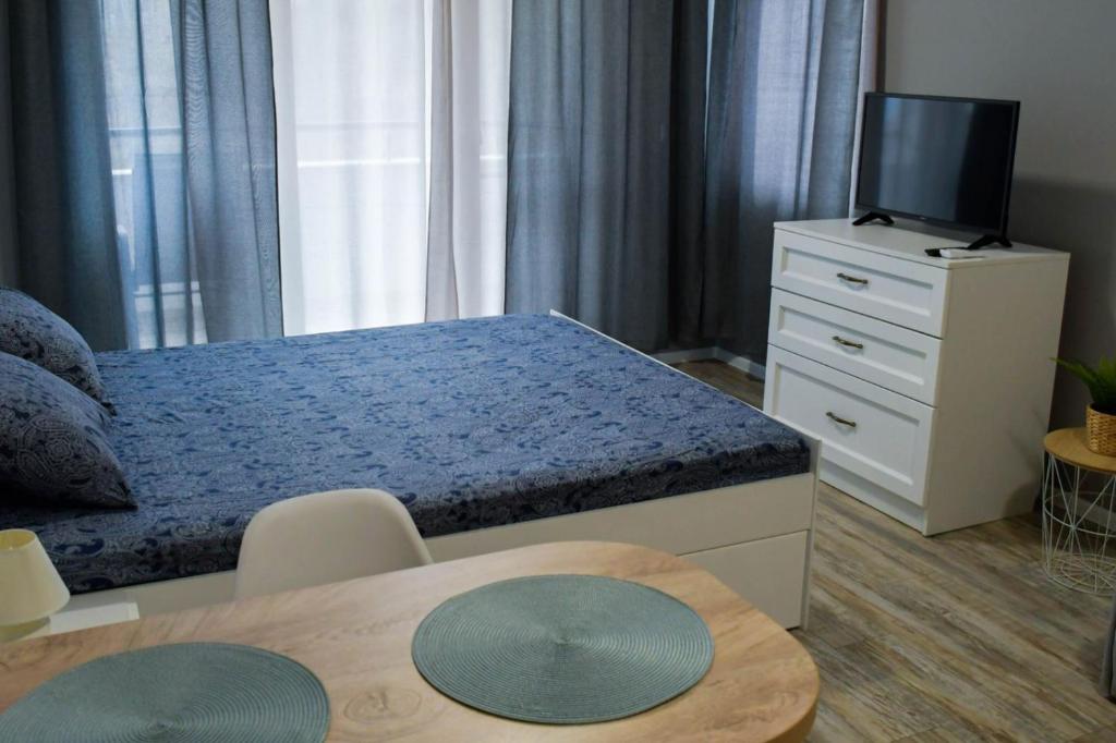 a bedroom with a bed and a tv and a table at Art Studio Sea in Shkorpilovtsi